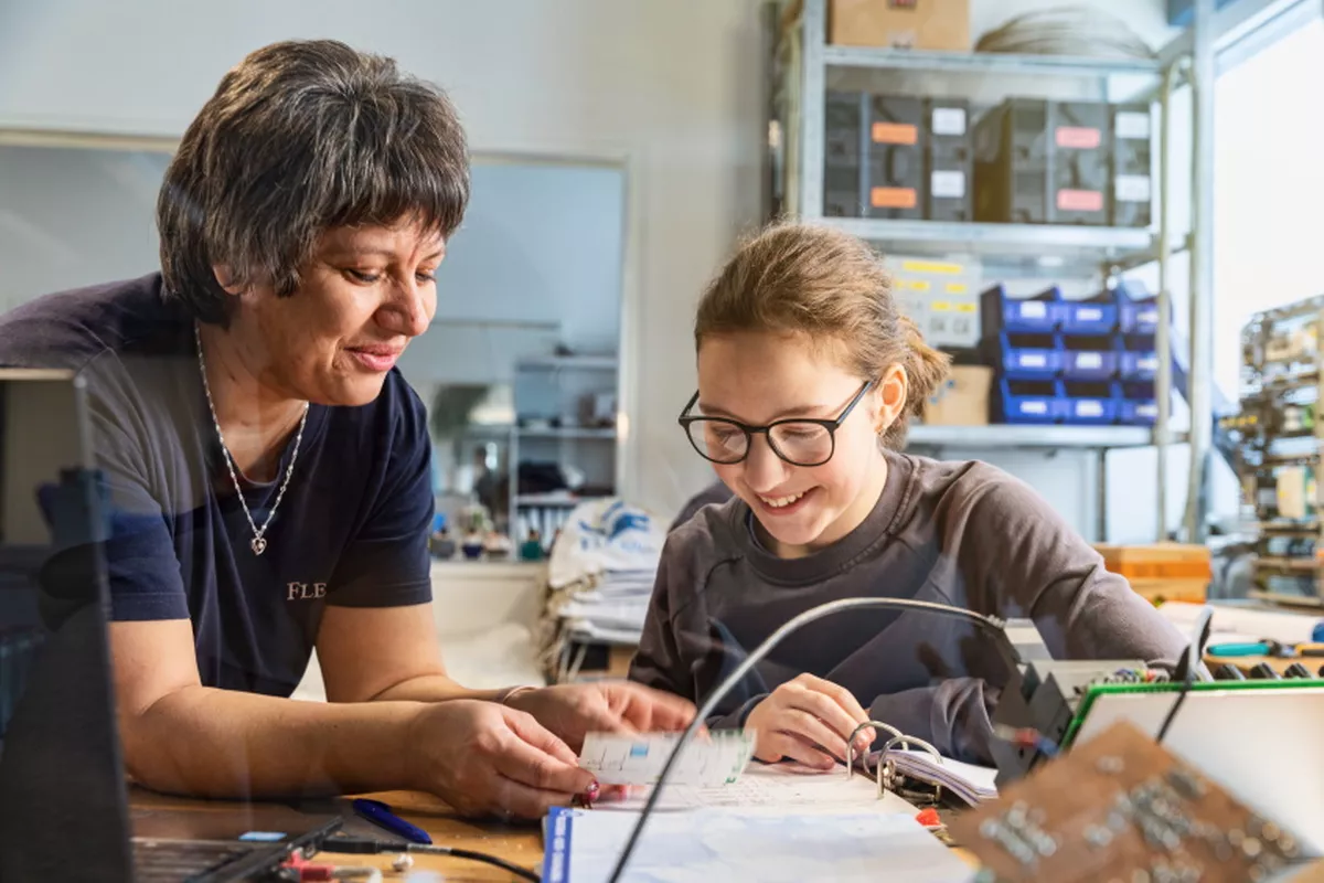 Lehrausbilderin mit Auszubildende in der Lehrwerkstatt