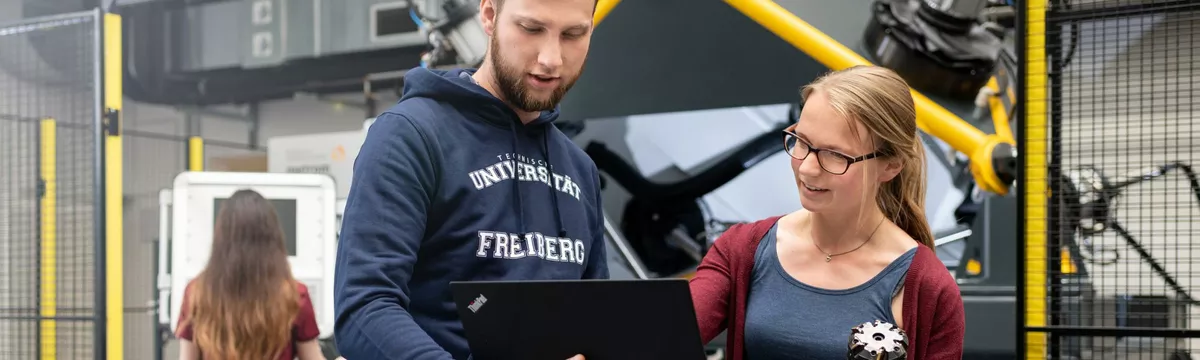 Ein Dozent erklärt einer Studentin eine technische Anlage