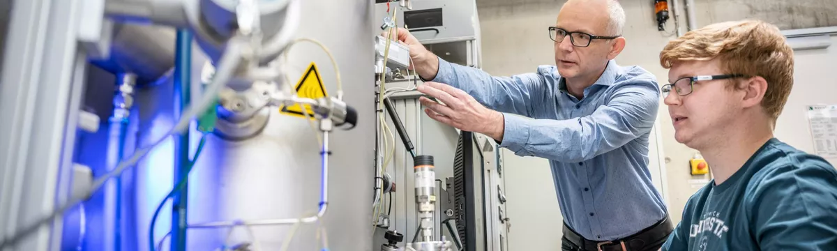 Ein Dozent und ein Student an einer technischen Anlage