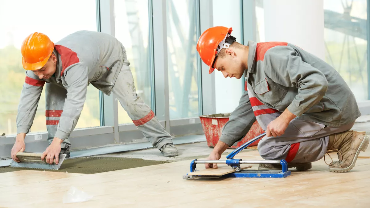 Fliesen-, Platten- und Mosaikleger bei der Arbeit.