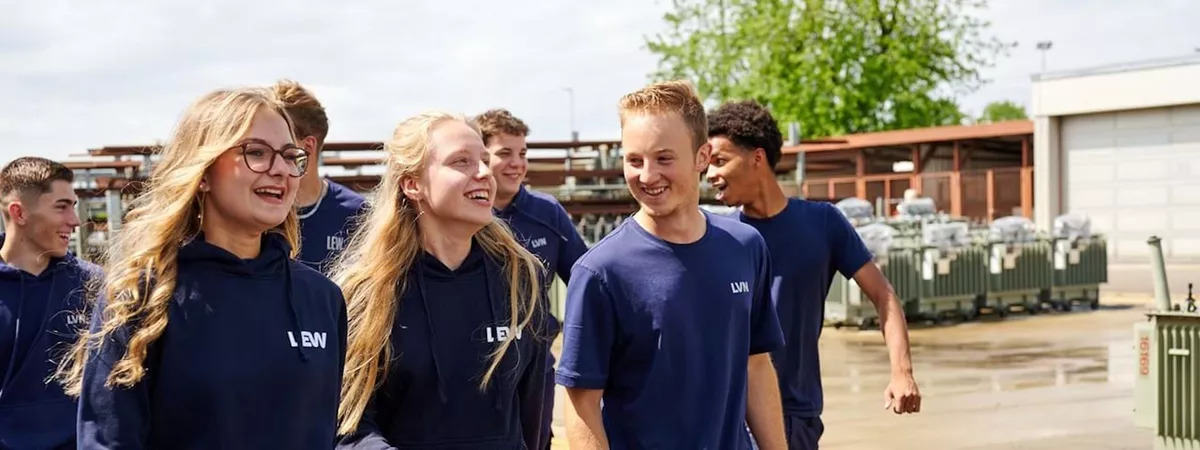 Gruppe von Auszubildenden laufen und unterhalten sich