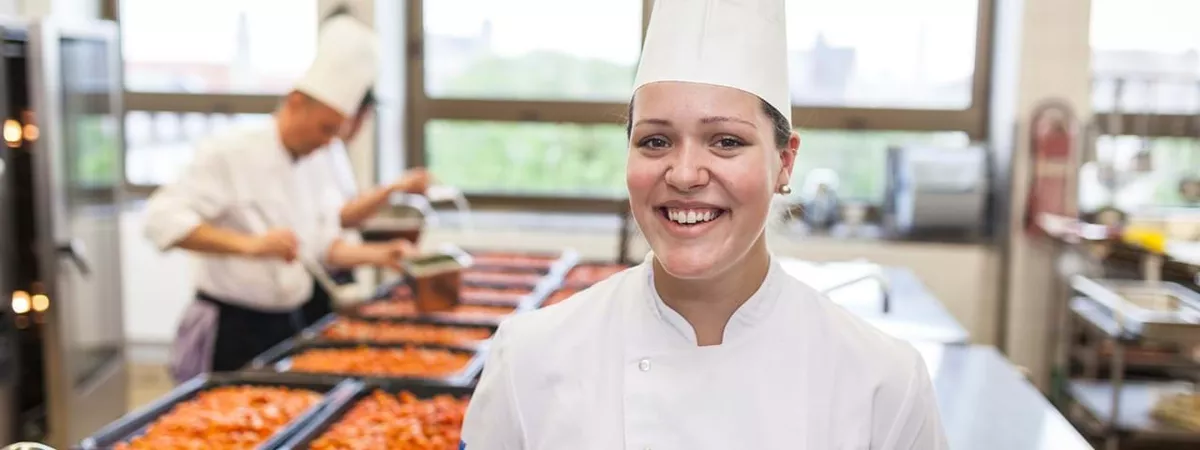 Junge Köchin bei der Zubereitung des Mittagessens im LEW-Betriebsrestaurant