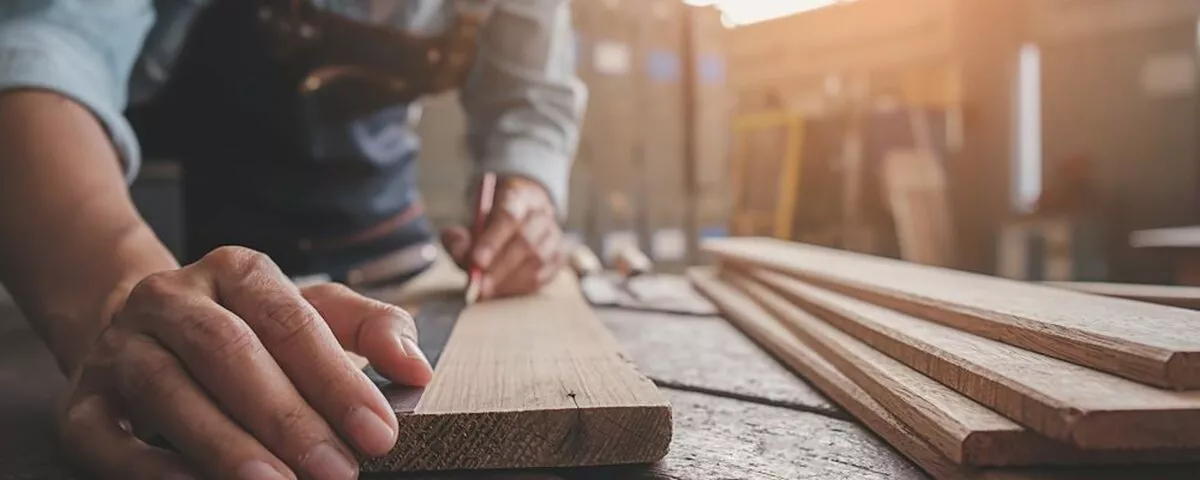 837b031-carpenter-working-with-equipment-wooden-table-carpentry-shop-1000x400