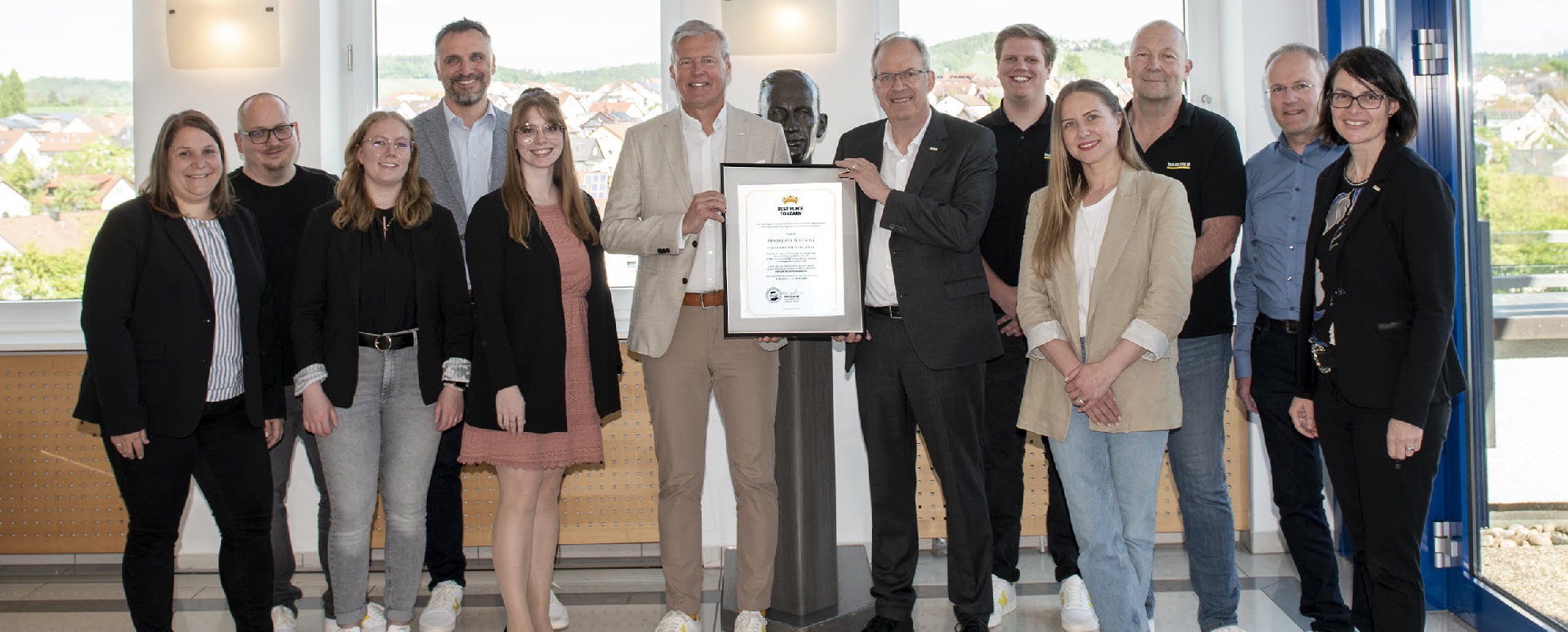 Hartmut Jenner, Vorsitzender des Vorstands, und Rüdiger Bechstein, Bereichsleiter Personal, halten das  BEST PLACE TO LEARN-Zertifikat.